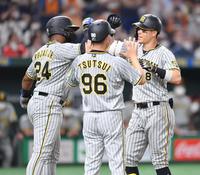 ３回、２ランを放ち、ロハス（左）とタッチを交わす佐藤輝（撮影・西岡正）