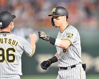 　１回、左翼線に先制打を放ち、筒井コーチ（左）とタッチを交わす佐藤輝（撮影・西岡正）