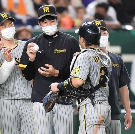 　ウイニングボールを手に梅野（右）を迎える才木