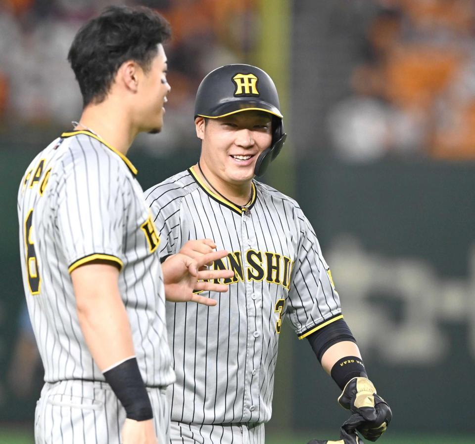 　８回、笑顔で佐藤輝とタッチを交わす大山（撮影・飯室逸平）