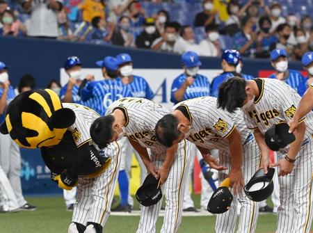 　２夜連続で完封負けを喫し、深々と頭を下げる矢野監督と勝利に沸くＤｅＮＡナイン（撮影・田中太一）