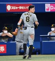 　７回、守備位置に行こうとして一旦ベンチへ戻る佐藤輝（撮影・飯室逸平）
