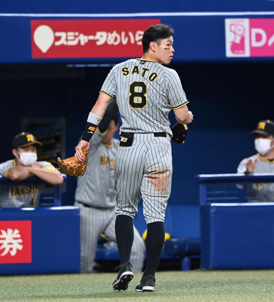 　７回、守備位置に行こうとして一旦ベンチへ戻る佐藤輝（撮影・飯室逸平）