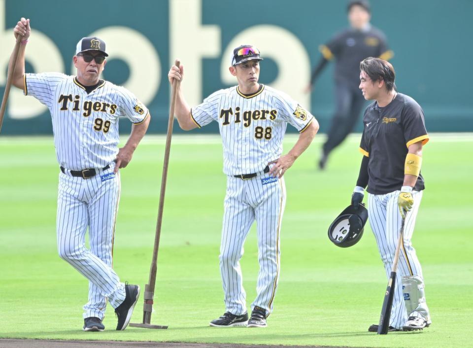 　梅野（右）と話す矢野監督（中央）、井上ヘッドコーチ（撮影・吉澤敬太）