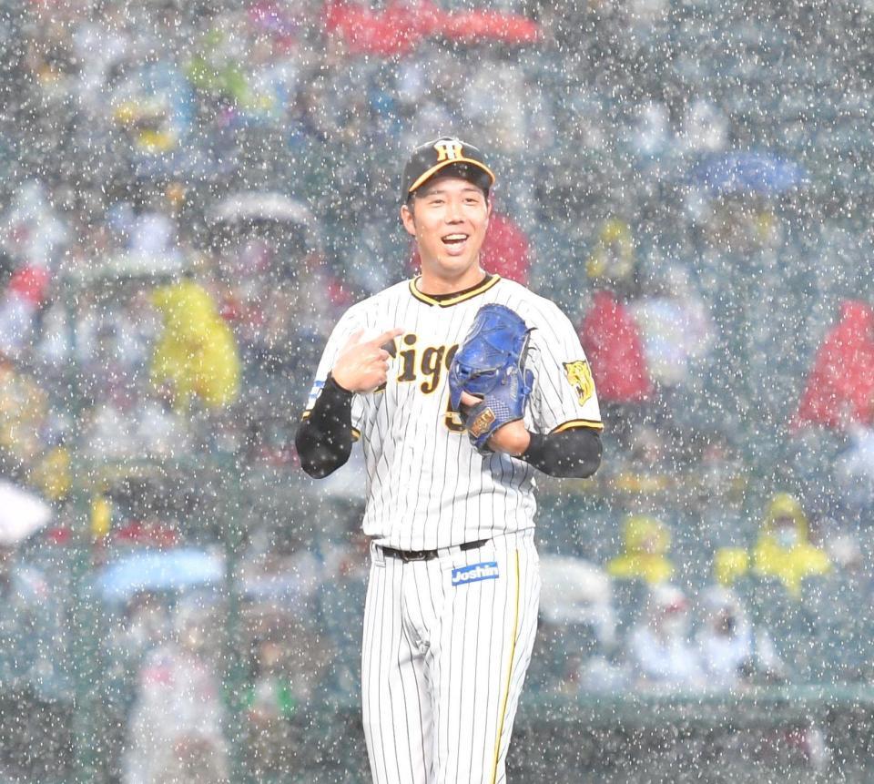 試合開始直前の大雨となり、“俺のせい？”と指さし苦笑いしながらベンチに戻る青柳（撮影・吉澤敬太）