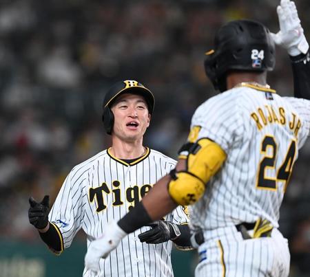 　７回、勝ち越しを喜ぶ近本とロハス（撮影・飯室逸平）