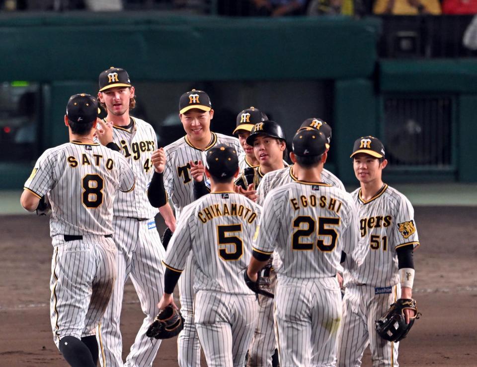 　広島に勝利し、大山（左から３人目）ら阪神ナインは笑顔でタッチする（撮影・山口登）