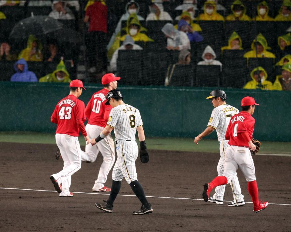 　６回途中、雨が強まり試合が中断し佐藤輝らはベンチに戻る（撮影・山口登）