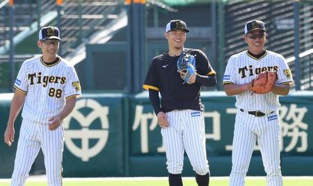 阪神・矢野燿大監督（左）、阪神・井上一樹コーチ（右）と談笑する阪神・佐藤輝明＝甲子園（撮影・田中太一）