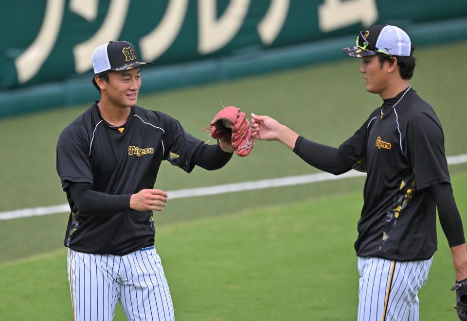 　キャッチボールを終え、タッチをかわす森木（左）と藤浪（撮影・飯室逸平）