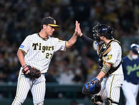 　完投勝利を飾った伊藤将は梅野とタッチし喜ぶ（撮影・山口登）