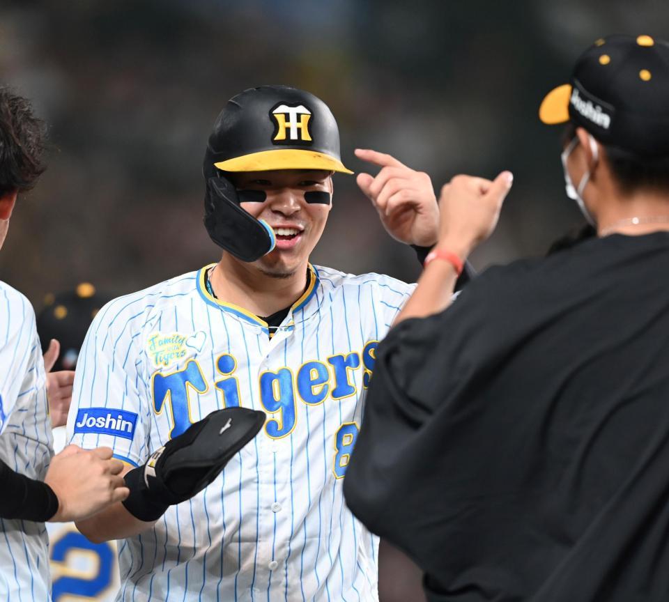 　６回、佐藤輝は木浪の適時二塁打で生還しナインの出迎えに笑顔を見せる（撮影・山口登）