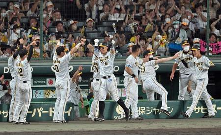 　６回、佐藤輝と小幡は梅野の適時三塁打で生還しナインに迎えられる（撮影・山口登）