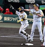 　６回、梅野は右中間に逆転適時三塁打を放ち、三塁上で喜ぶ（撮影・山口登）