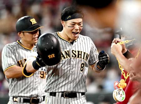 　６回、２０号２ランを放った佐藤輝はナインに迎えられ喜ぶ（撮影・田中太一）