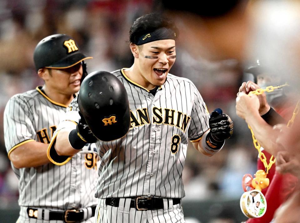 　６回、２０号２ランを放った佐藤輝はナインに迎えられ喜ぶ（撮影・田中太一）