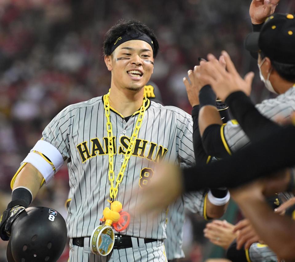 　６回、２０号２ランを放った佐藤輝はナインに迎えられ笑顔を見せる（撮影・田中太一）