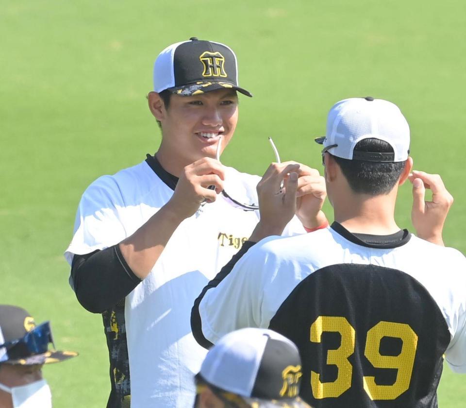 　栄枝（右）とサングラスを交換する西純（撮影・高部洋祐）