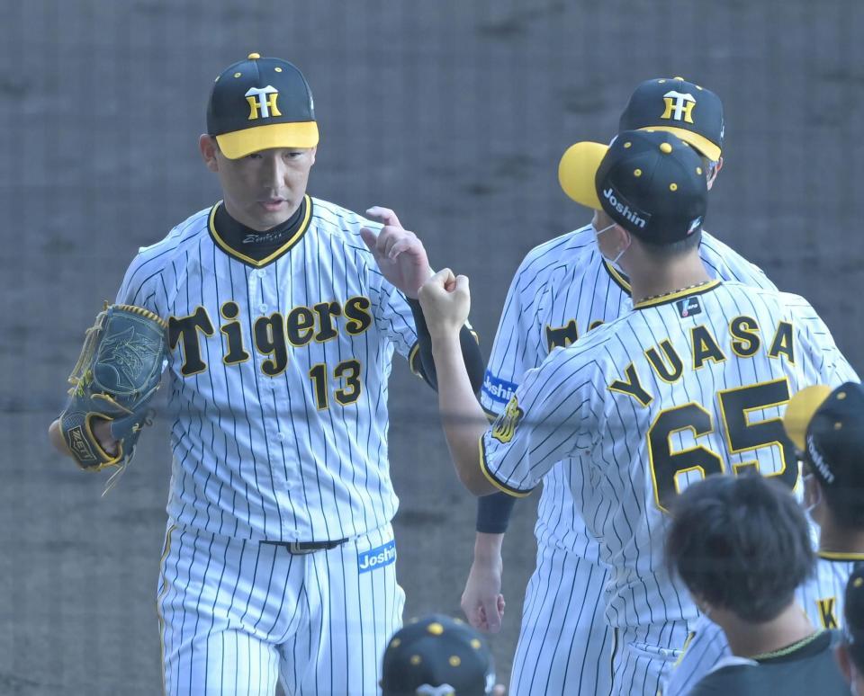 　６回を投げ終え、湯浅（６５）とタッチを交わす岩崎（撮影・高部洋祐）