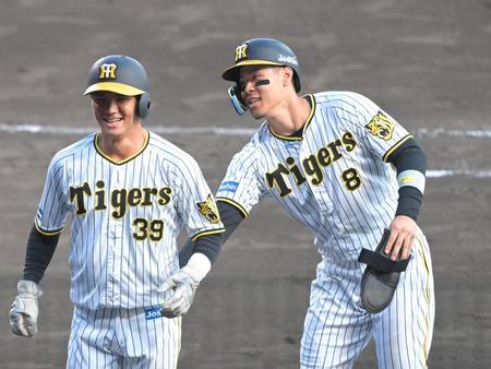 　９回終了後、同点打を放った栄枝（左）を祝福する佐藤輝（撮影・高部洋祐）