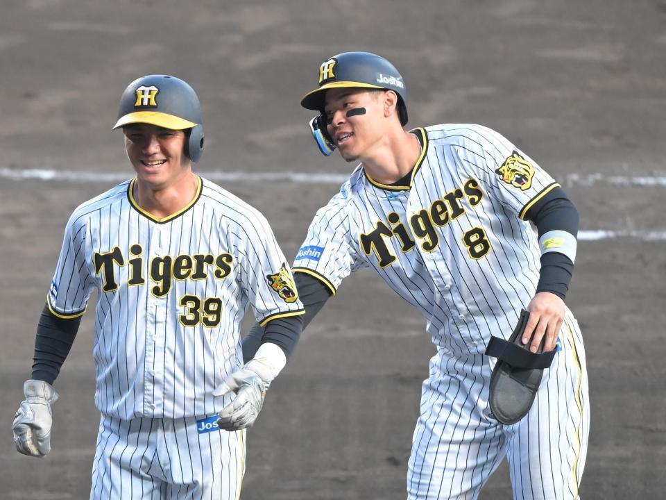 　９回終了後、同点打を放った栄枝（左）を祝福する佐藤輝（撮影・高部洋祐）