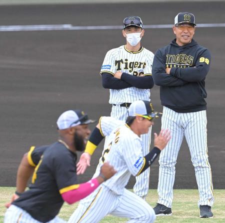 　井上コーチ（右）と共にナインの練習を見守る矢野監督
