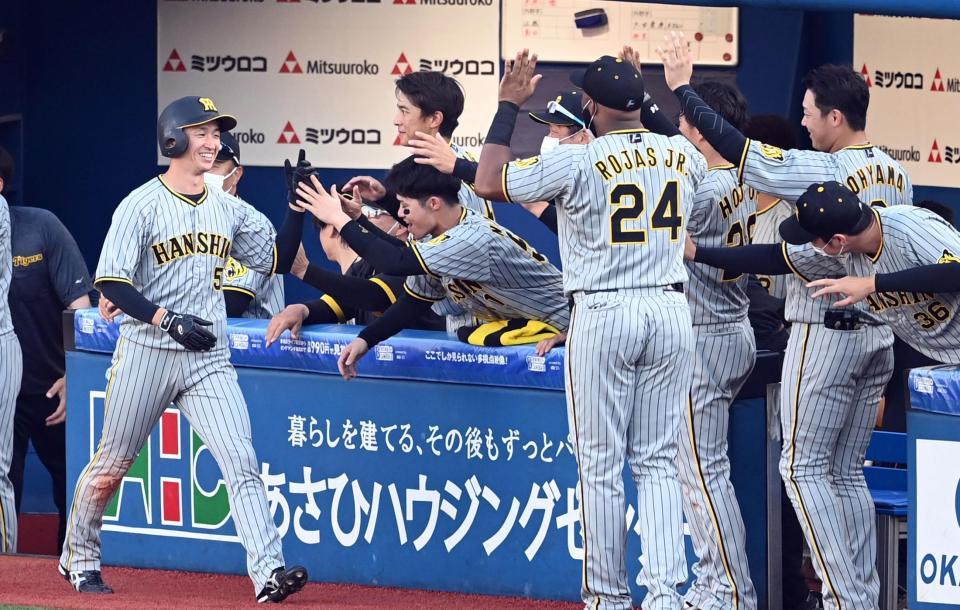 　６回、勝ち越しに笑顔でタッチを交わす近本ら阪神ナイン（撮影・飯室逸平）