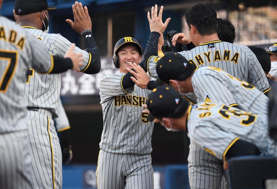 　６回、同点打の近本は原口の適時打で生還し、ナインに迎えられる（撮影・田中太一）