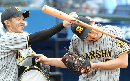 　守備練習中に先輩から厳しい指導？島田（左）に頭をコツッとされ笑顔の湯浅＝１０日（撮影・堀内翔）