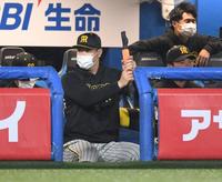 　ベンチで練習器具を手に素振りする佐藤輝（撮影・棚橋慶太）