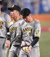 　悔しそうな表情でベンチに引き揚げる近本（右）＝撮影・園田高夫