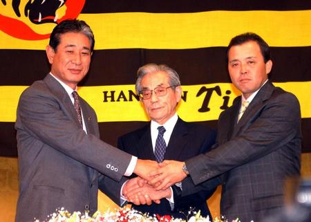 　星野監督（左）からバトンを受けた岡田監督。中央は久万オーナー＝０３年