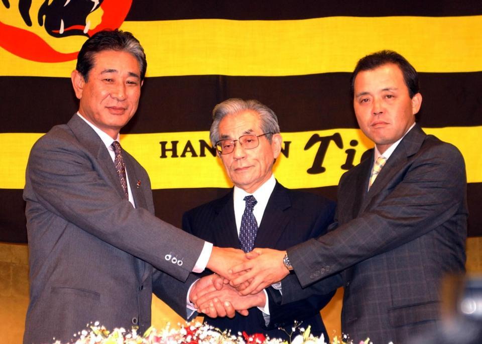 　星野監督（左）からバトンを受けた岡田監督。中央は久万オーナー＝０３年