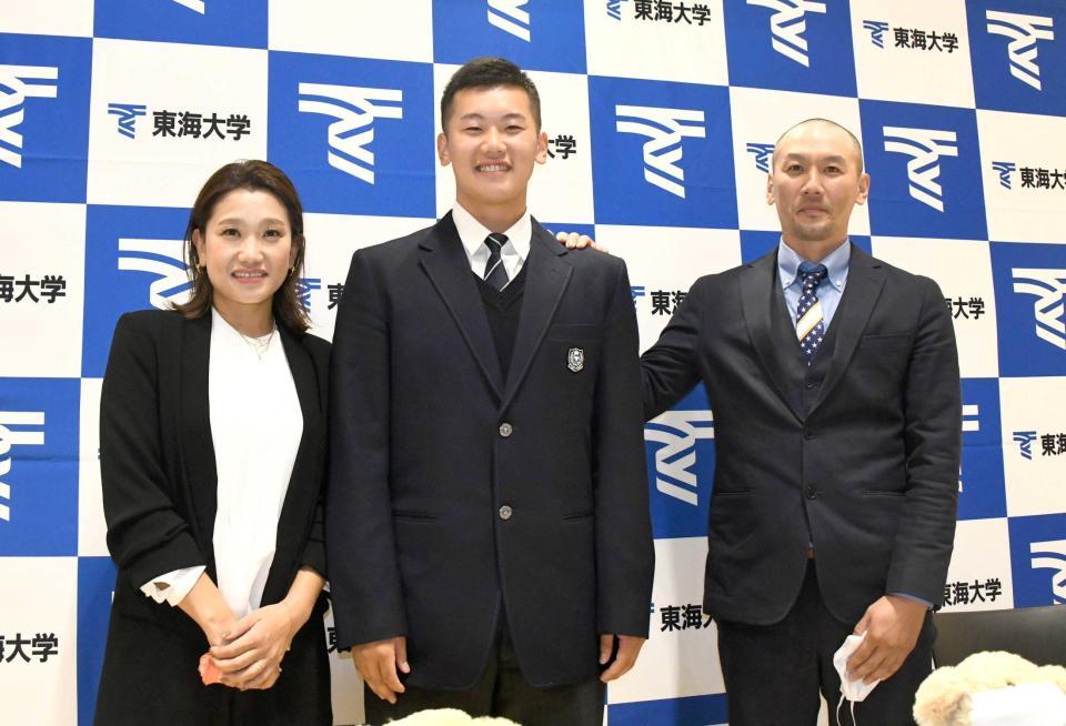 　阪神からドラフト２位指名を受けた東海大札幌・門別（中央）は母の実保さん（左）と父の竜也さんから祝福を受ける