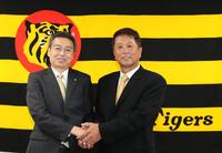 握手を交わす百北幸司球団社長（左）と水口１軍打撃コーチ（代表撮影）