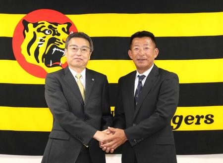 　握手を交わす百北球団社長（左）と馬場１軍内野守備走塁コーチ（代表撮影）