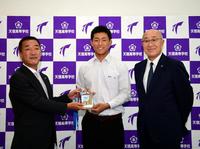 　天理高校・戸井零士は指名あいさつを終え、山本スカウト（左）から岡田監督のサインが入ったドラフト会議のカードを贈られる。（右は畑山統括スカウト）＝撮影・山口登