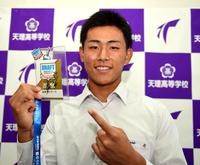 　天理高校・戸井零士は岡田監督のサインが入ったドラフト会議のカードを手に笑顔を見せる（撮影・山口登）