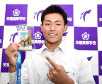 　岡田監督のサインが入ったドラフト会議のカードを手に笑顔の天理・戸井