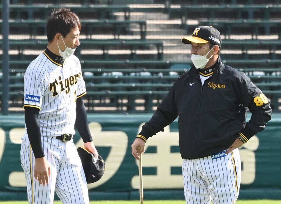 　練習前、岩崎（左）と話をする岡田監督（撮影・田中太一）