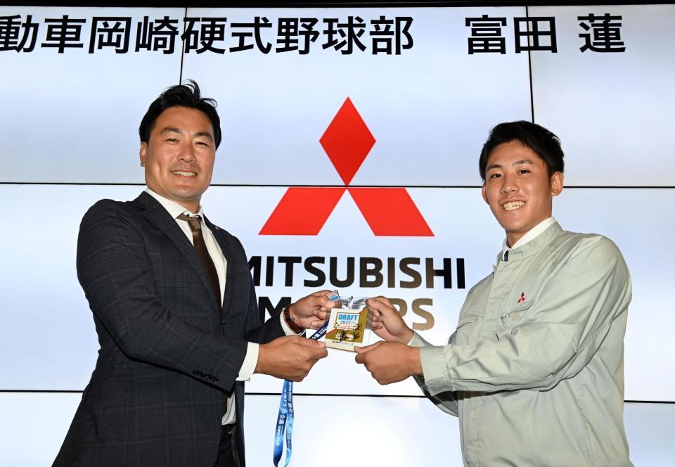 　阪神に６位で指名された富田蓮（右）は、筒井和也スカウトから岡田監督のサインが入ったドラフト会議のパスを受け取る＝三菱自動車岡崎製作所（撮影・山口登）