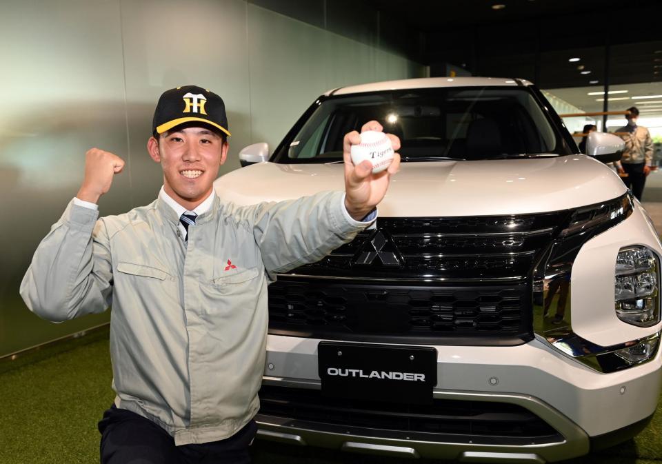 　笑顔を見せポーズを決める富田蓮＝三菱自動車岡崎製作所（撮影・山口登）