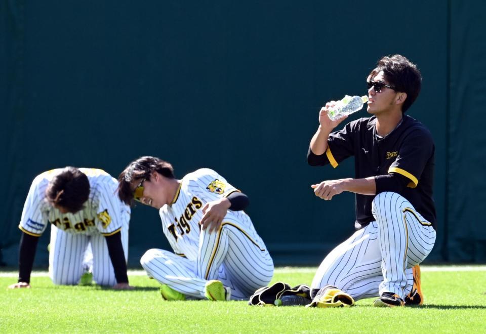 　伊藤将（右）は走り込みをし水分補給をする（撮影・山口登）