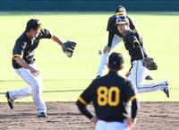 　二遊間ノックで渡辺（左）にグラブトスをする中野。手前は岡田監督（撮影・田中太一）