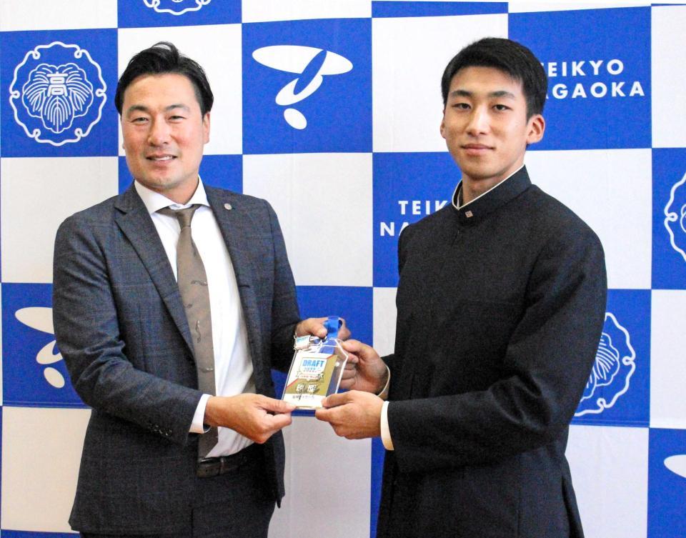 　筒井スカウトから岡田監督のサインパスを受け取る帝京長岡・茨木（右）