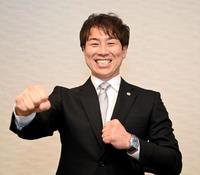 　就任会見を終え、笑顔でポーズを決める山崎２軍打撃コーチ（撮影・飯室逸平）