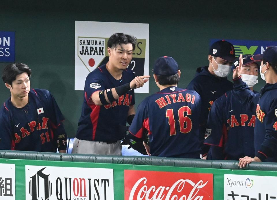 　ベンチで宮城らに迎えられ、Ｚポーズで応える佐藤輝（撮影・高石航平）