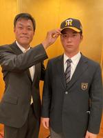 　平塚スカウトに帽子を被せてもらうドラフト３位の関東第一・井坪陽生（球団提供）