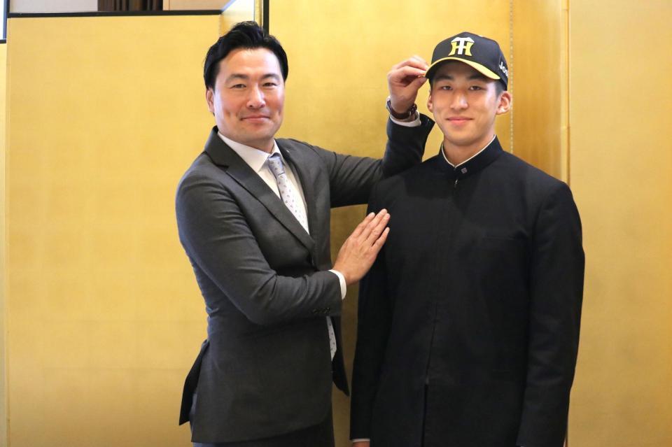 　阪神と仮契約を交わし帽子をかぶせてもらう帝京長岡・茨木（阪神タイガース提供）