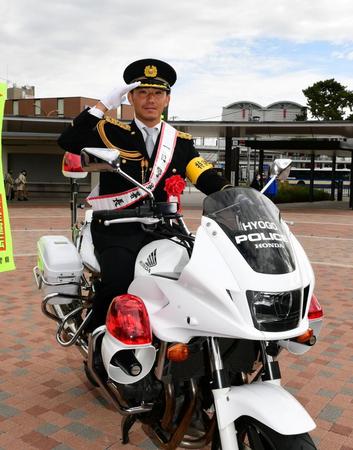 　伊藤将は甲子園署の一日警察署長を務め、白バイにまたがり敬礼をする（撮影・山口登）